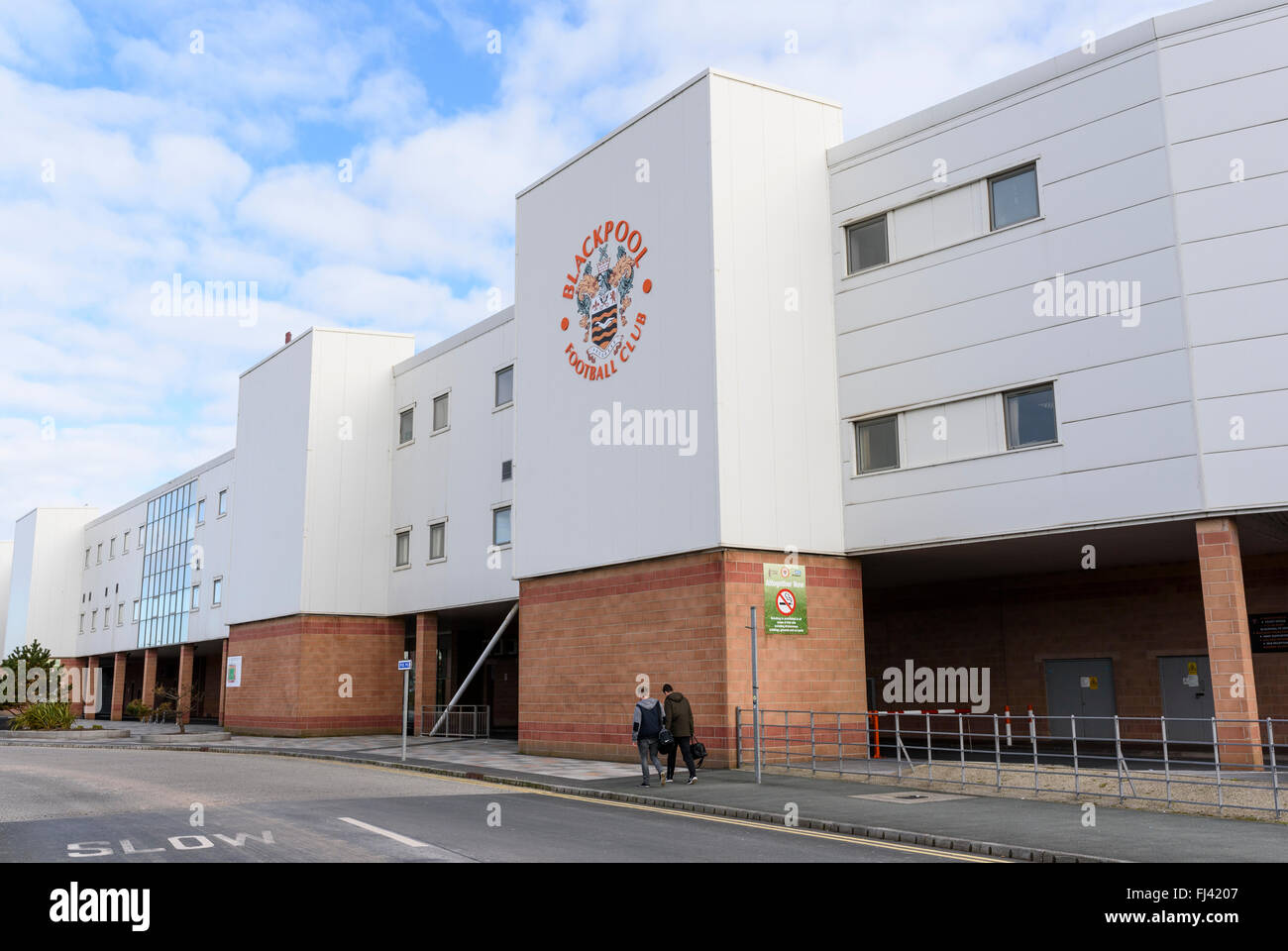 Two men walk past the outside of Blackpool Football Club Stock Photo