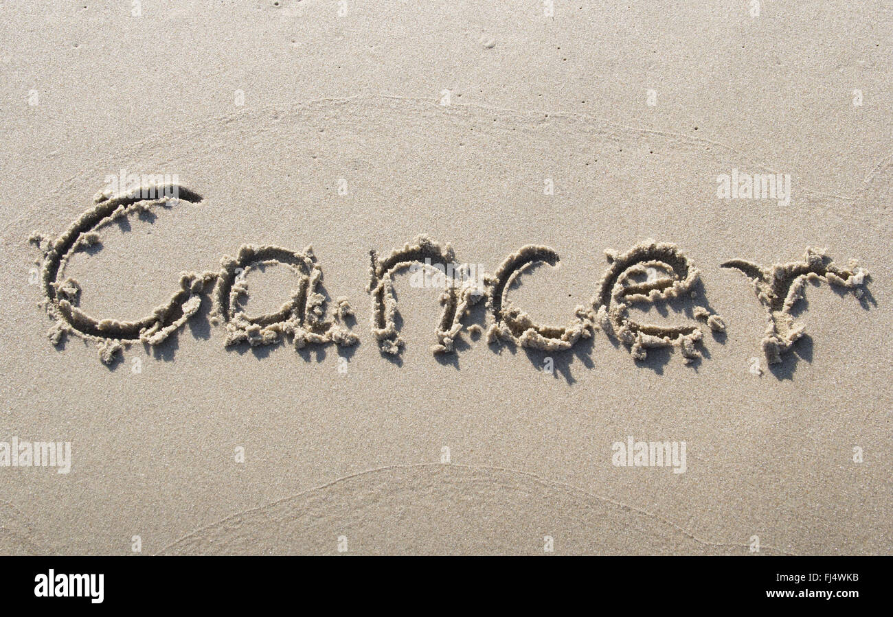 'Cancer' written in sand Stock Photo