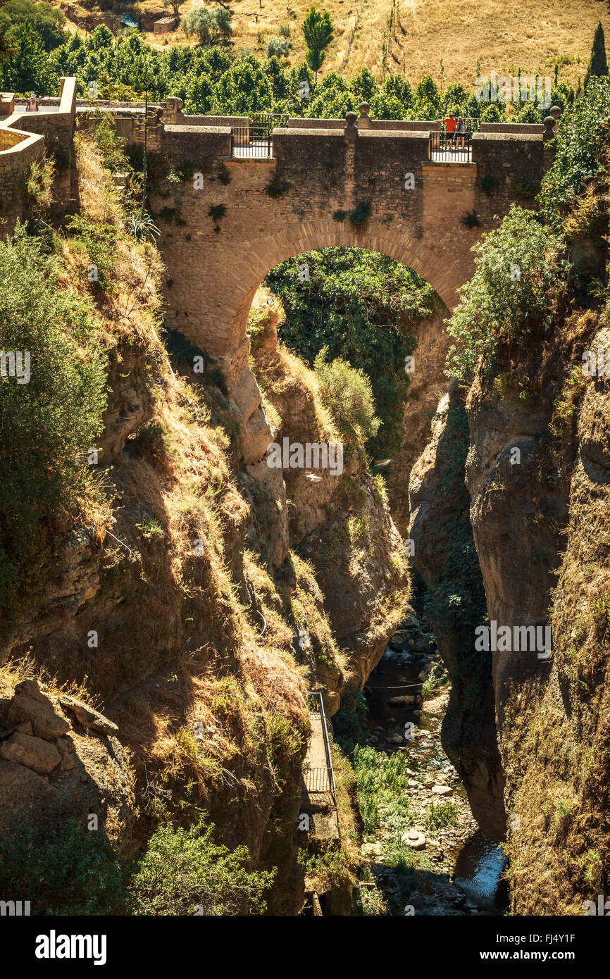 The Puente Viejo - Old Bridge is oldest and smallest of three bridges that span the 120-metre deep chasm that carries Guadalevin Stock Photo