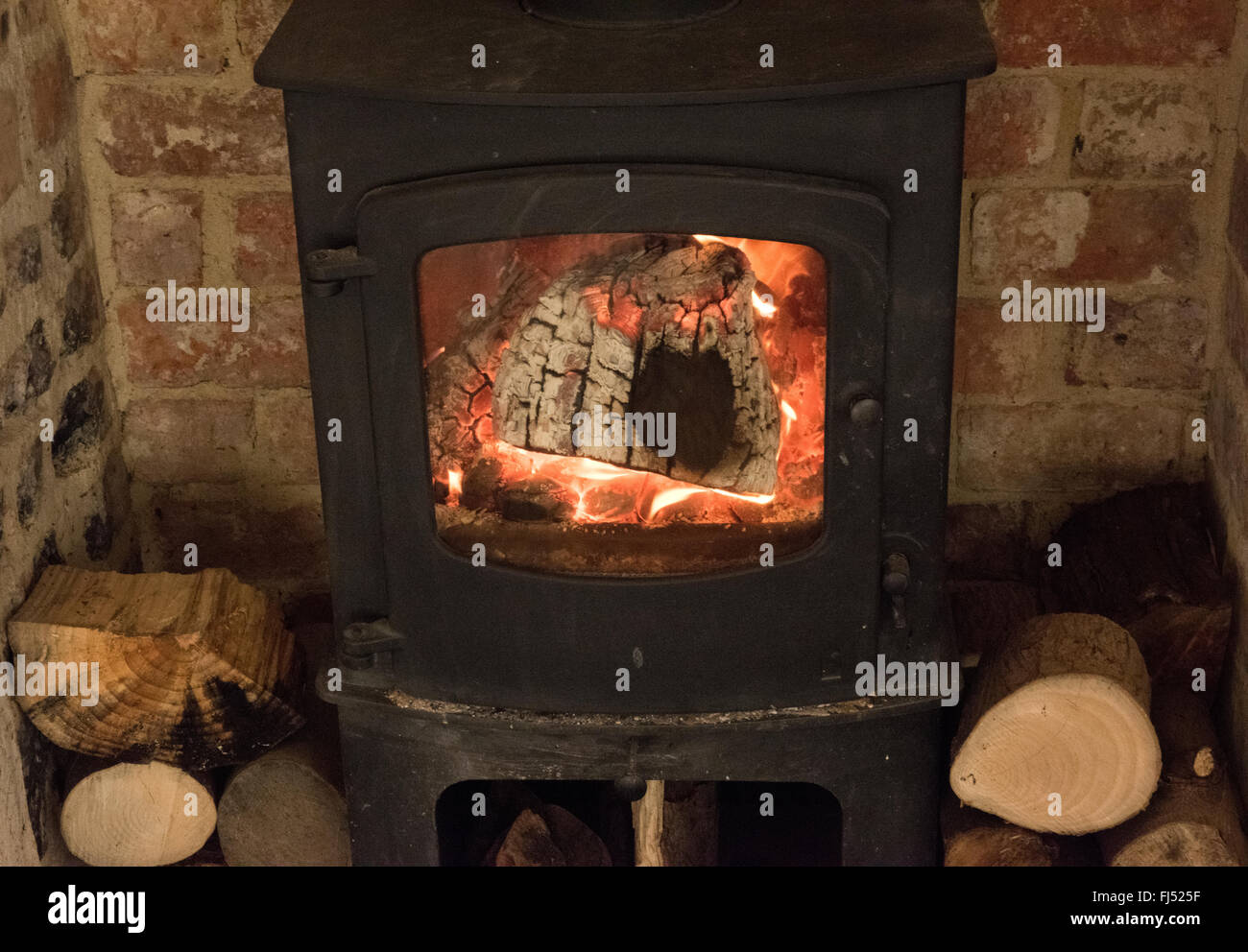Close-up view of logburner with chopped logs at side Stock Photo