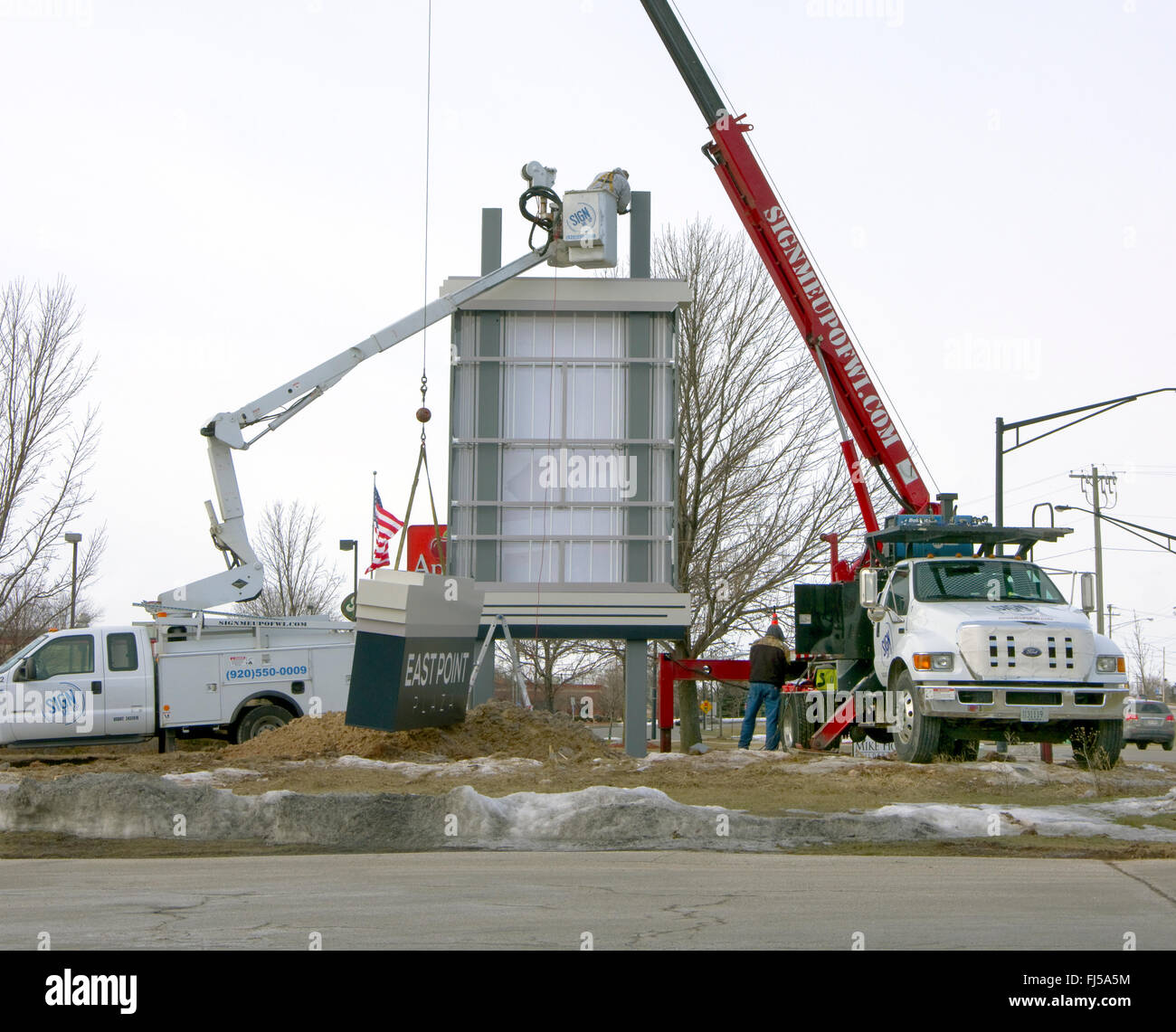 Worker Installing Sign Post Workers installing sign for shopping mall Stock Photo - Alamy