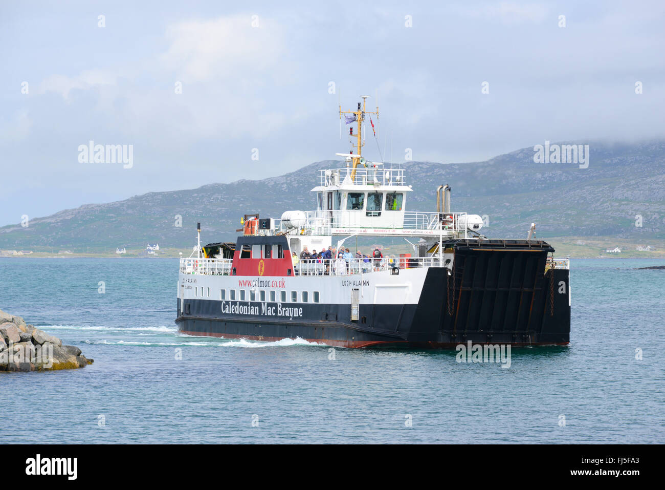 Eriskay to Barra Calmac ferry rounding the harbour wall on Eriskay, South Uist, Outer Hebrides, Scotland Stock Photo