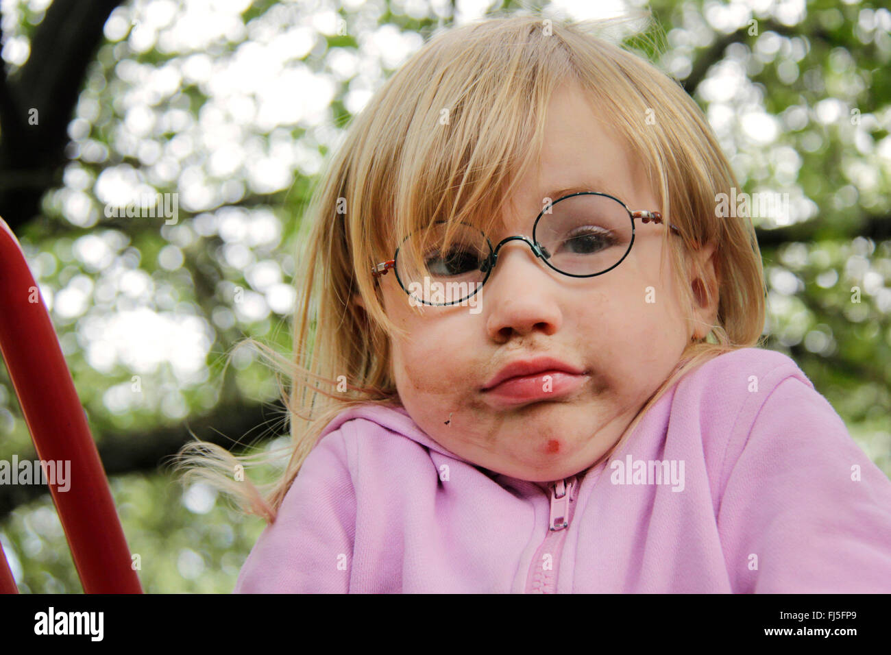 little girl with smeared face giving a shrug, portrait of a child Stock Photo