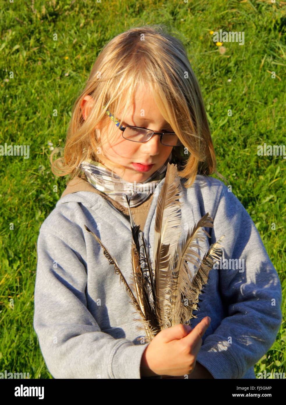 little boy with collected fetahers in the hand, portrait of a child Stock Photo