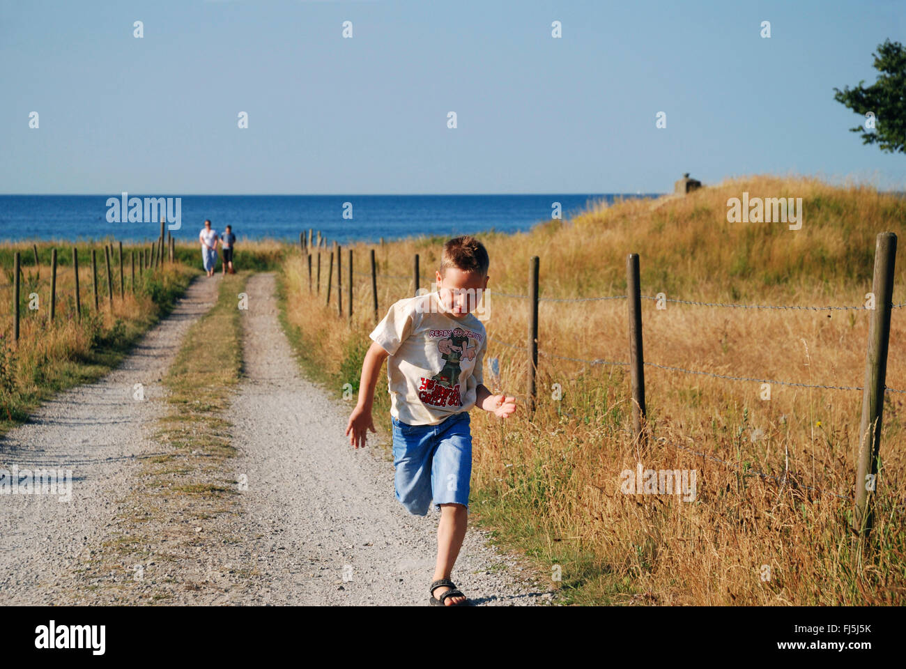 little boy running on a field path at the Baltic Sea Coast, Sweden Stock Photo