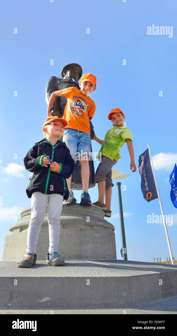 three boys climbing at a statue Stock Photo