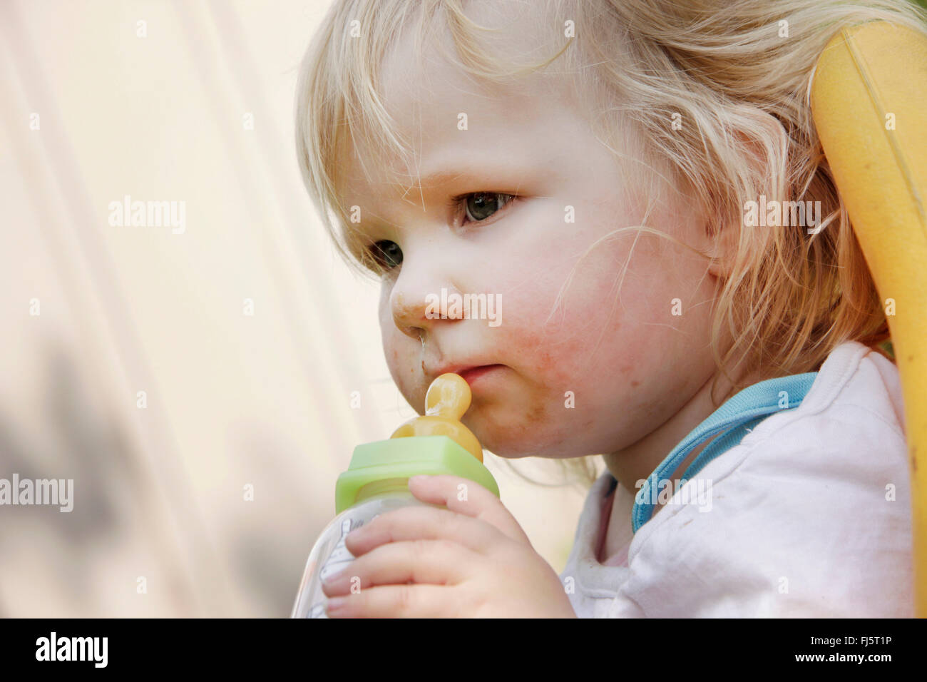 little girl with feeding bootle, Germany Stock Photo