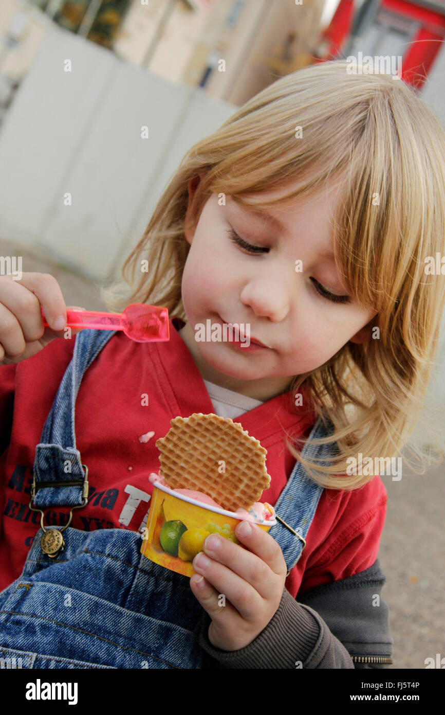 little boy eating appreciatively an ice cream, Germany Stock Photo