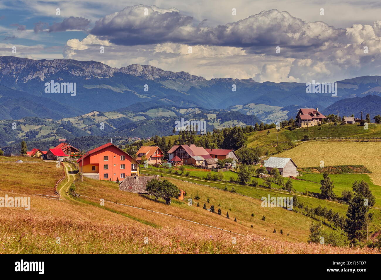Rural mountain scenery with Romanian houses in the valleys of the Bucegi mountains, in Pestera village, Brasov county, Romania. Stock Photo