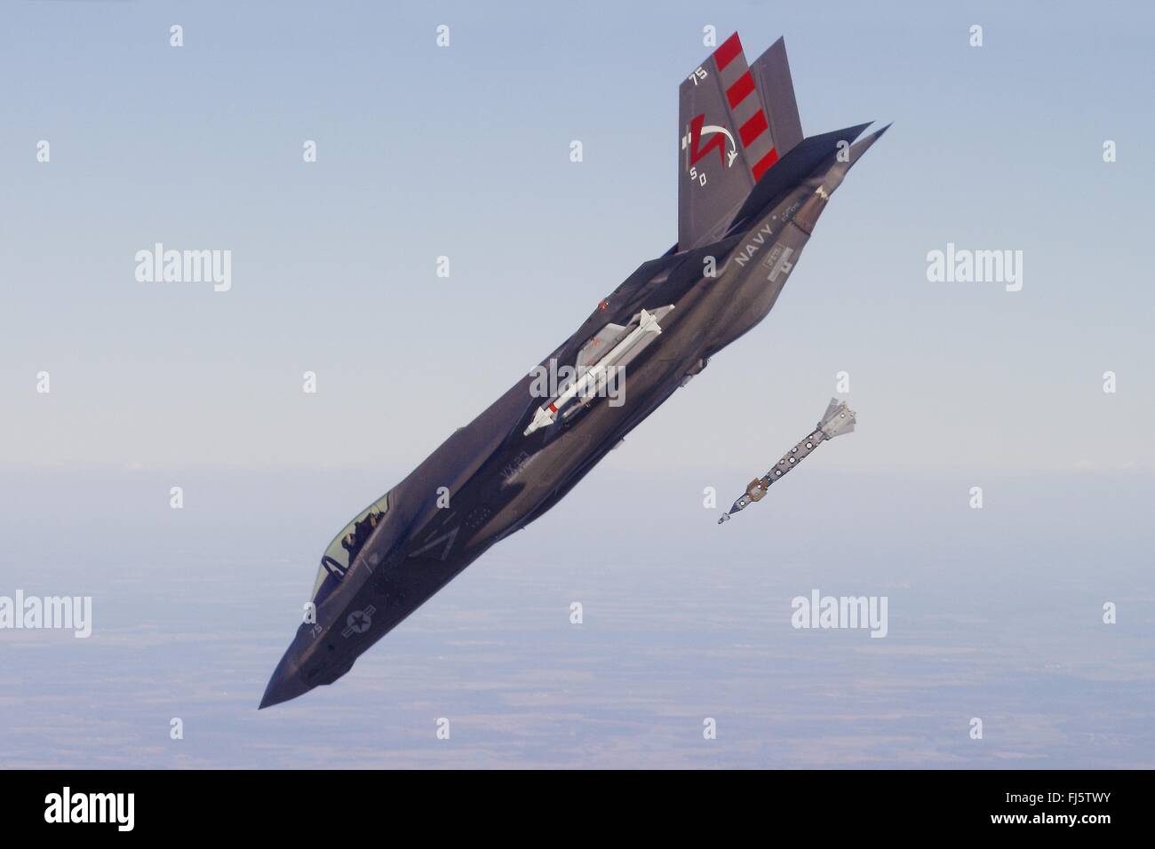 U.S. Navy F-35C Lightning II stealth fighter carrier variant enters a 45-degree dive dropping a GBU-12 Paveway II laser-guided smart bomb during a weapons test February 19, 2016 near NAS Patuxent River, Maryland. Stock Photo