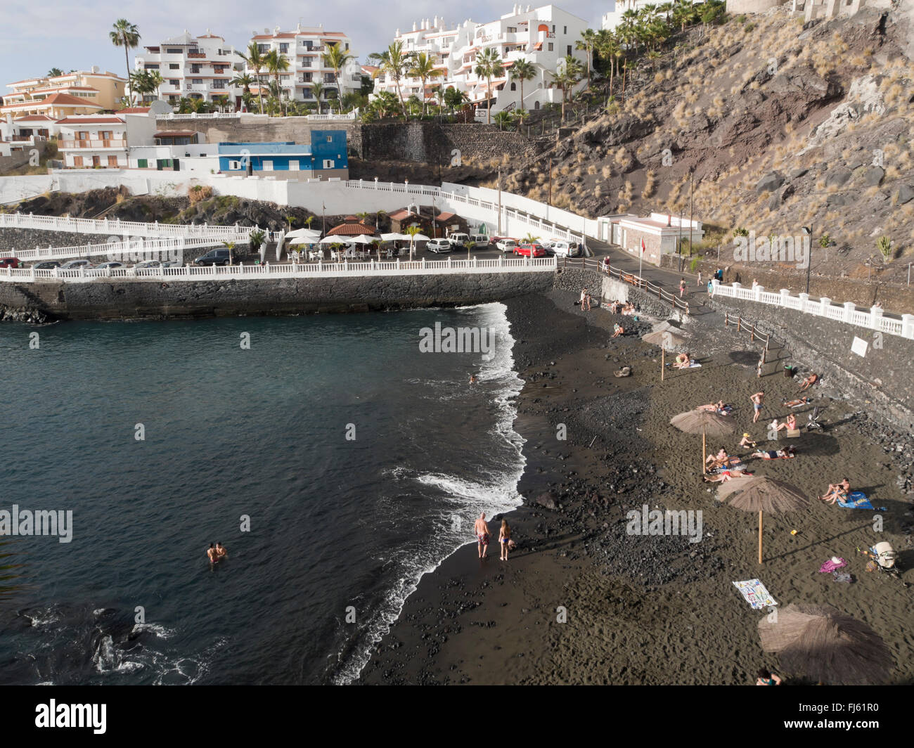 The harbour/ beach in Puerto de Santiago with black lava sand, holiday destination on the west coast of Tenerife Canary Islands Stock Photo