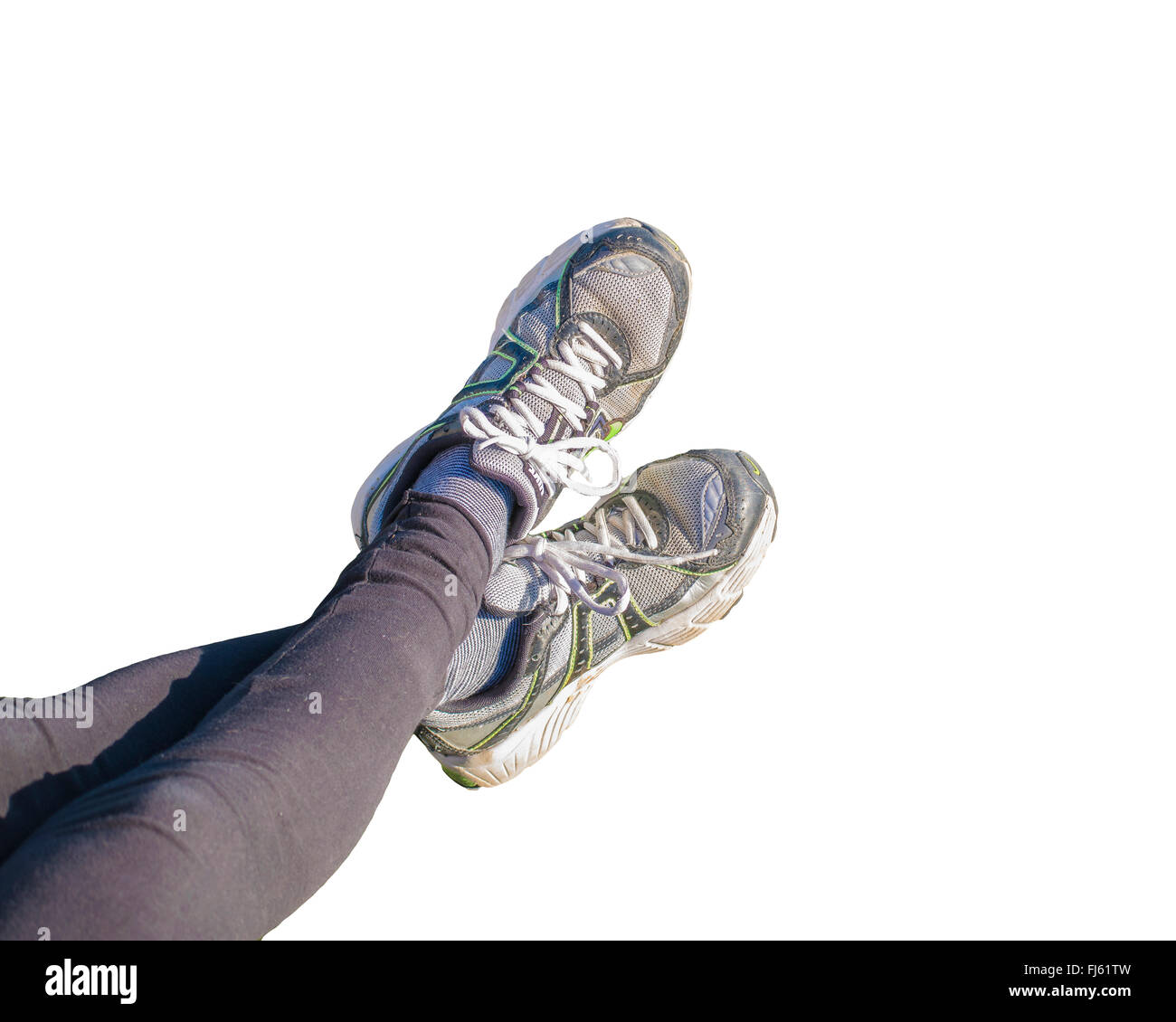 High angle prespective view of woman legs with black leggings and sports sneakers isolated in white background. Stock Photo