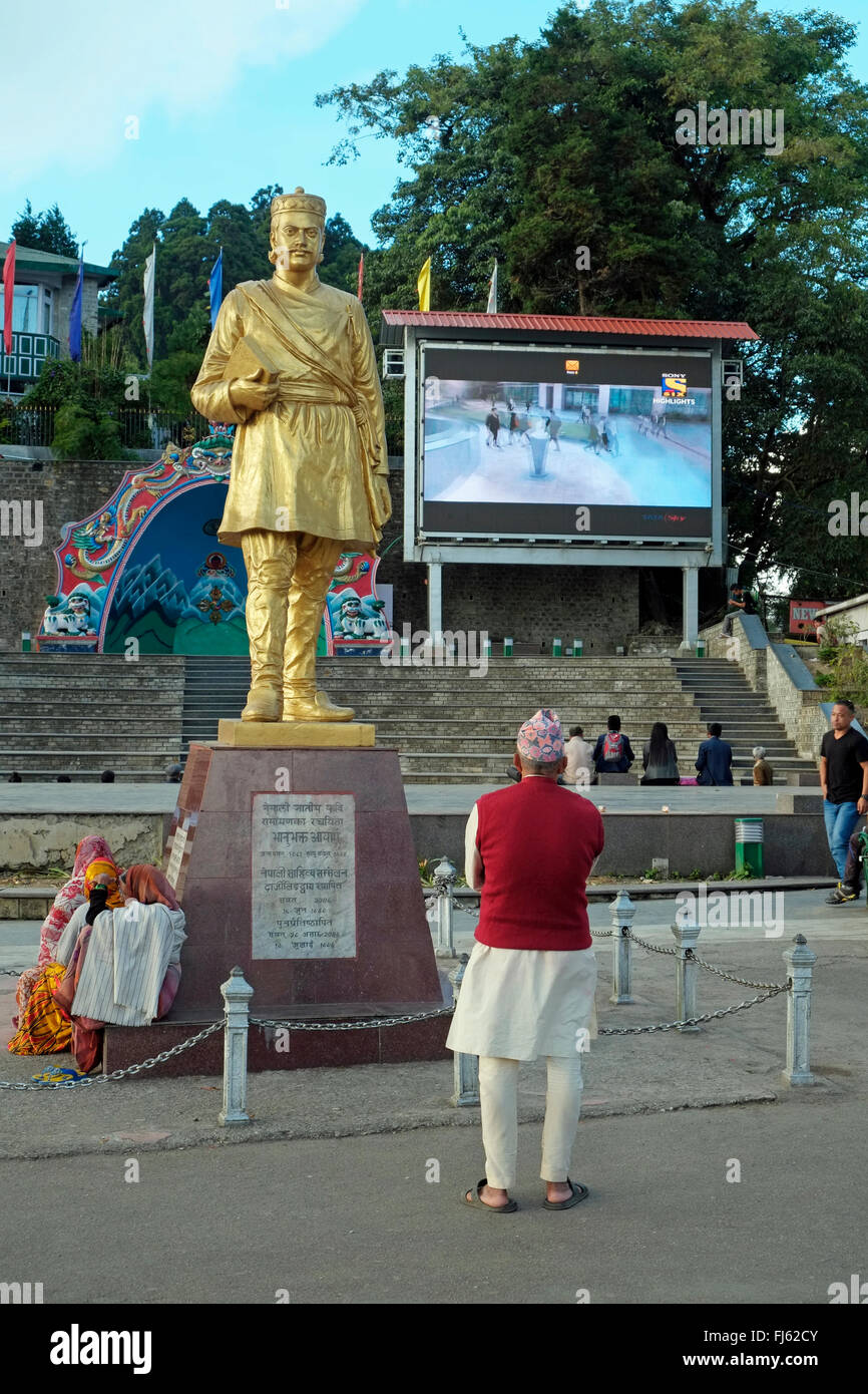 Senior Indian man watching a large TV screen erected at the Chowrasta (main square), Darjeeling, West Bengal, India. Stock Photo