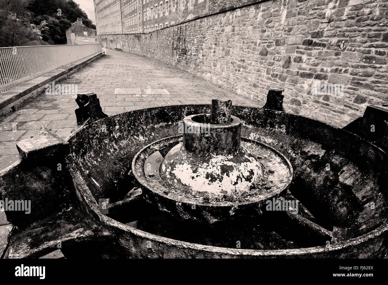 The mill yard at New Lanark, with the antique water turbine in the foreground Stock Photo