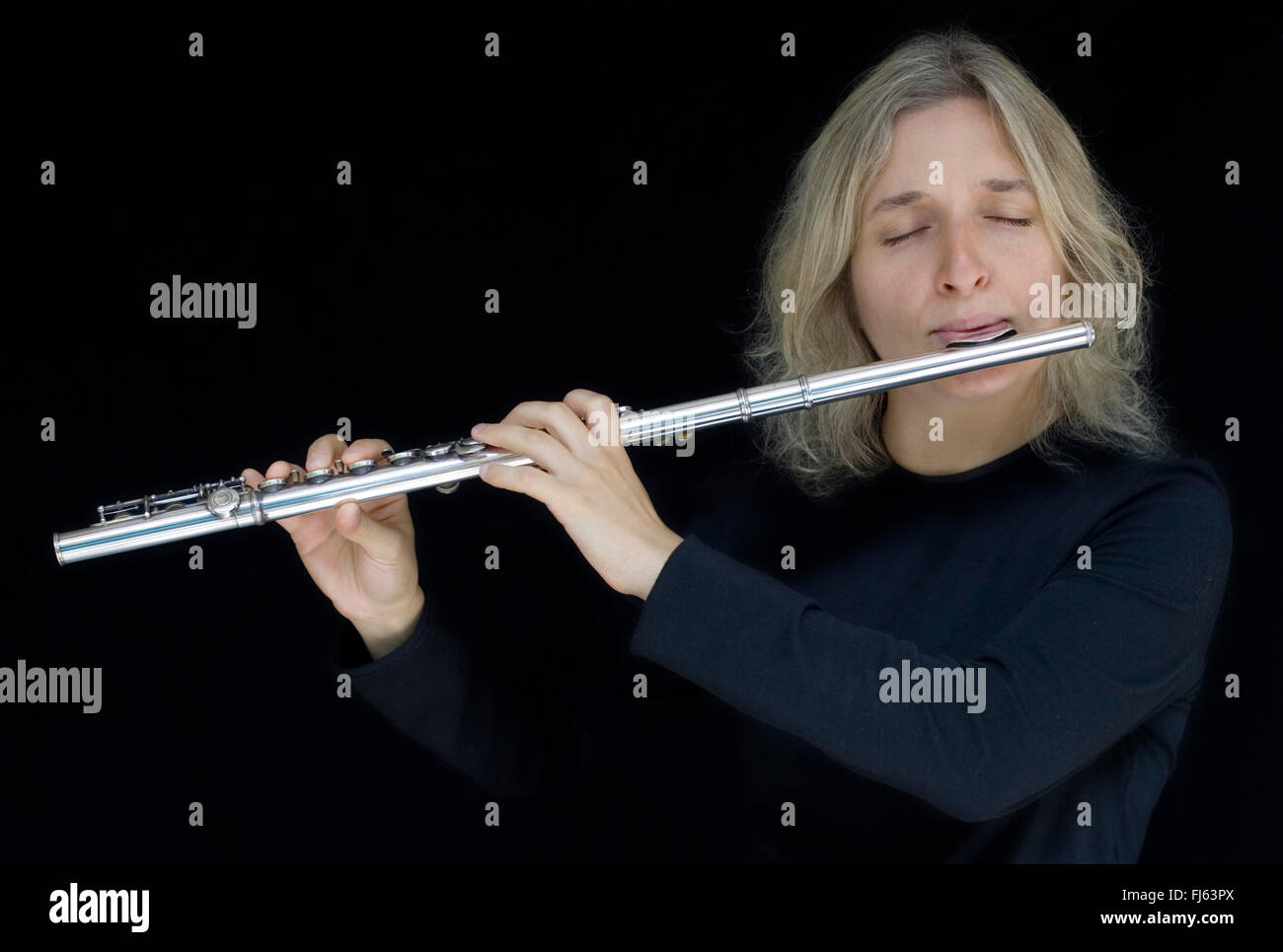flute player in black background Stock Photo