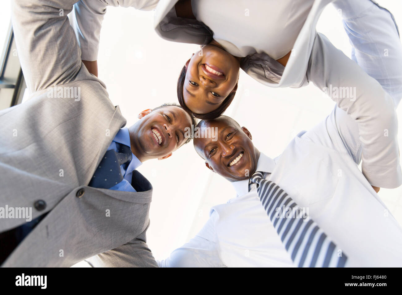 underneath view of businesspeople in a circle looking down Stock Photo