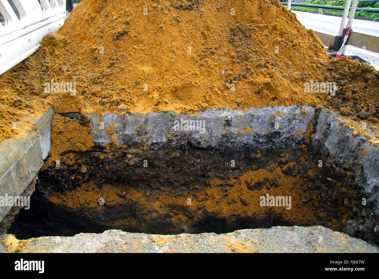 cordoned off building pit with heap of sand on a road, Germany Stock Photo