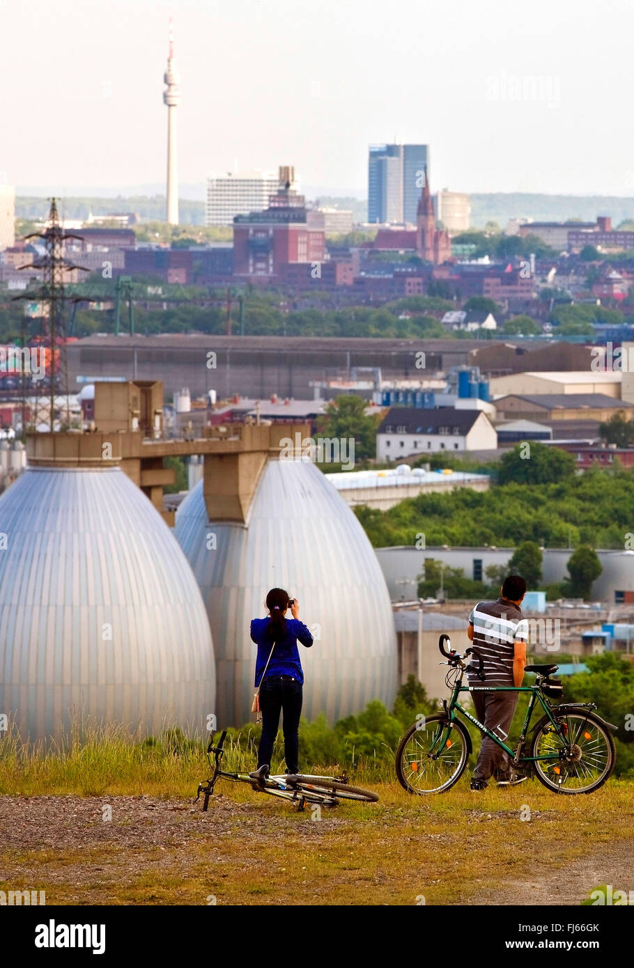 two cyclists on former waste disposal Deusenberg enjoying the view to Dortmund, Germany, North Rhine-Westphalia, Ruhr Area, Dortmund Stock Photo