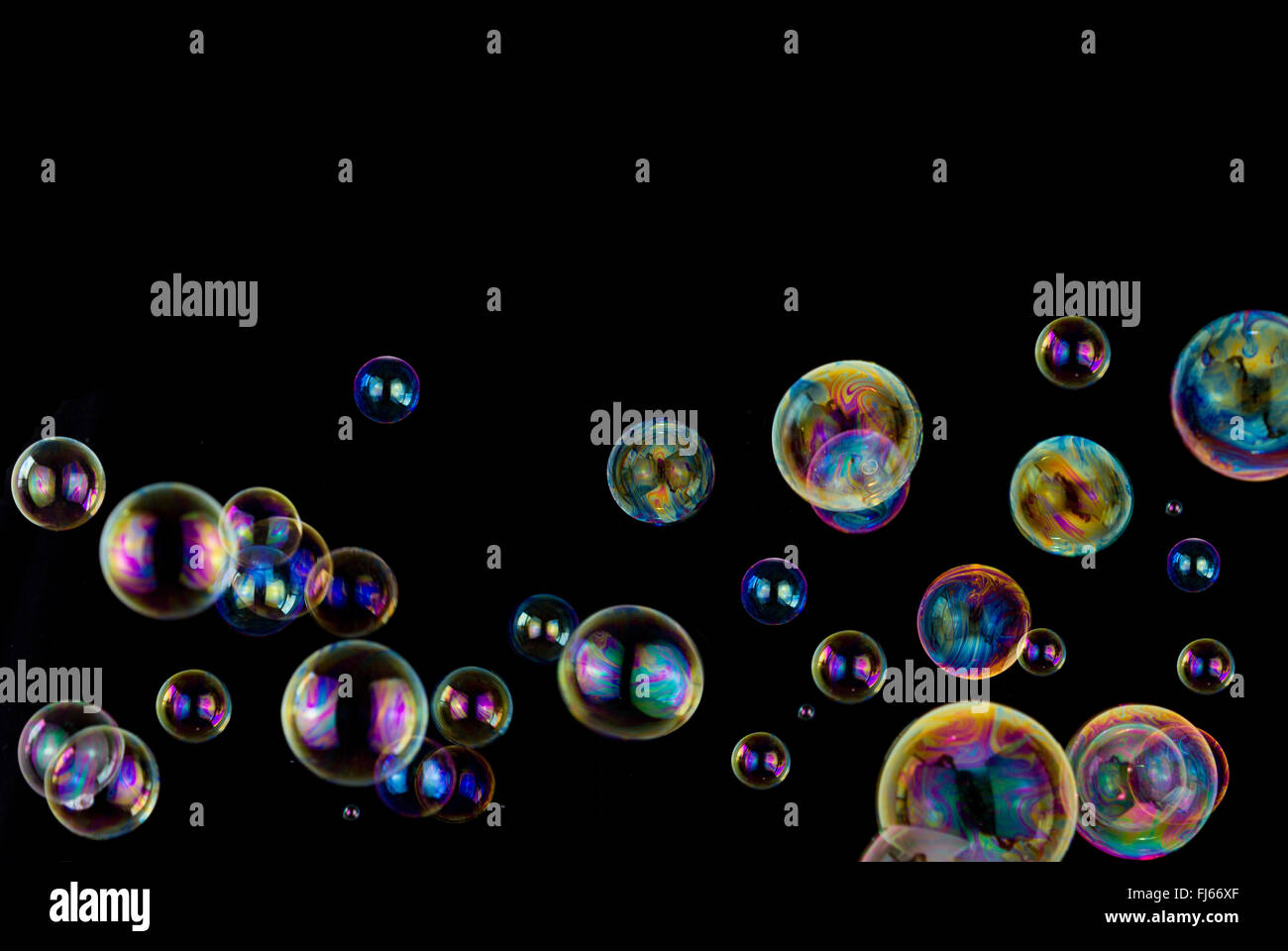 many colorful soap bubbles on black background with copy space Stock Photo