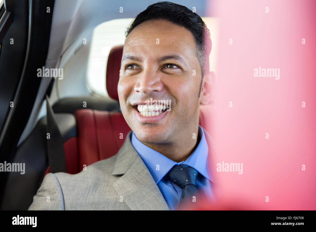 handsome middle aged businessman sitting on the backseat in a car Stock Photo
