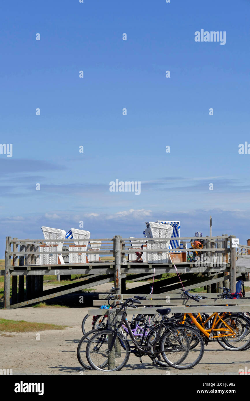 parked bicycles and platform for beach chairs on the beach, Northern Frisia, Sankt Peter-Ording Stock Photo