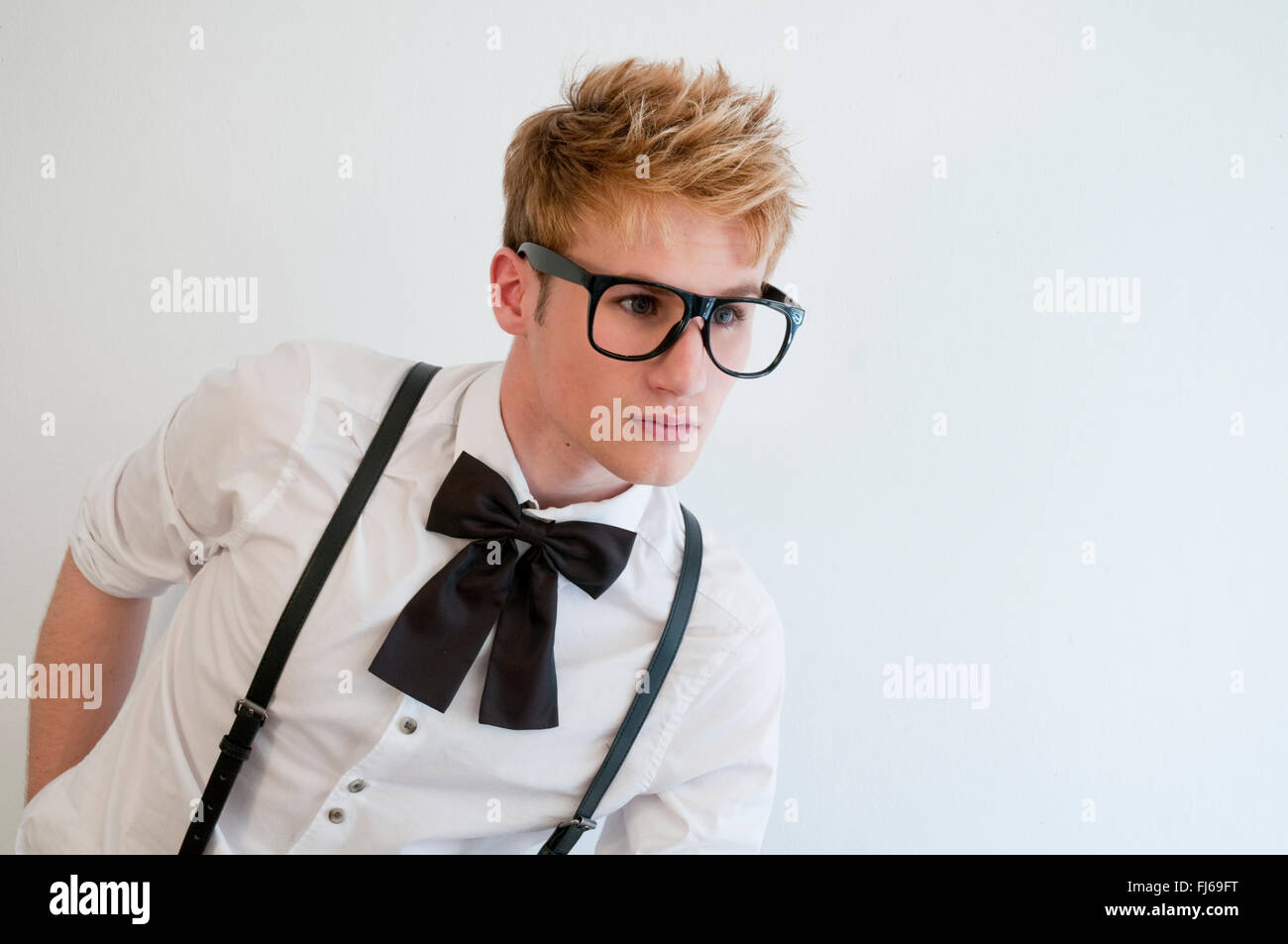 Young man wearing bow, braces and big eyeglasses. Stock Photo
