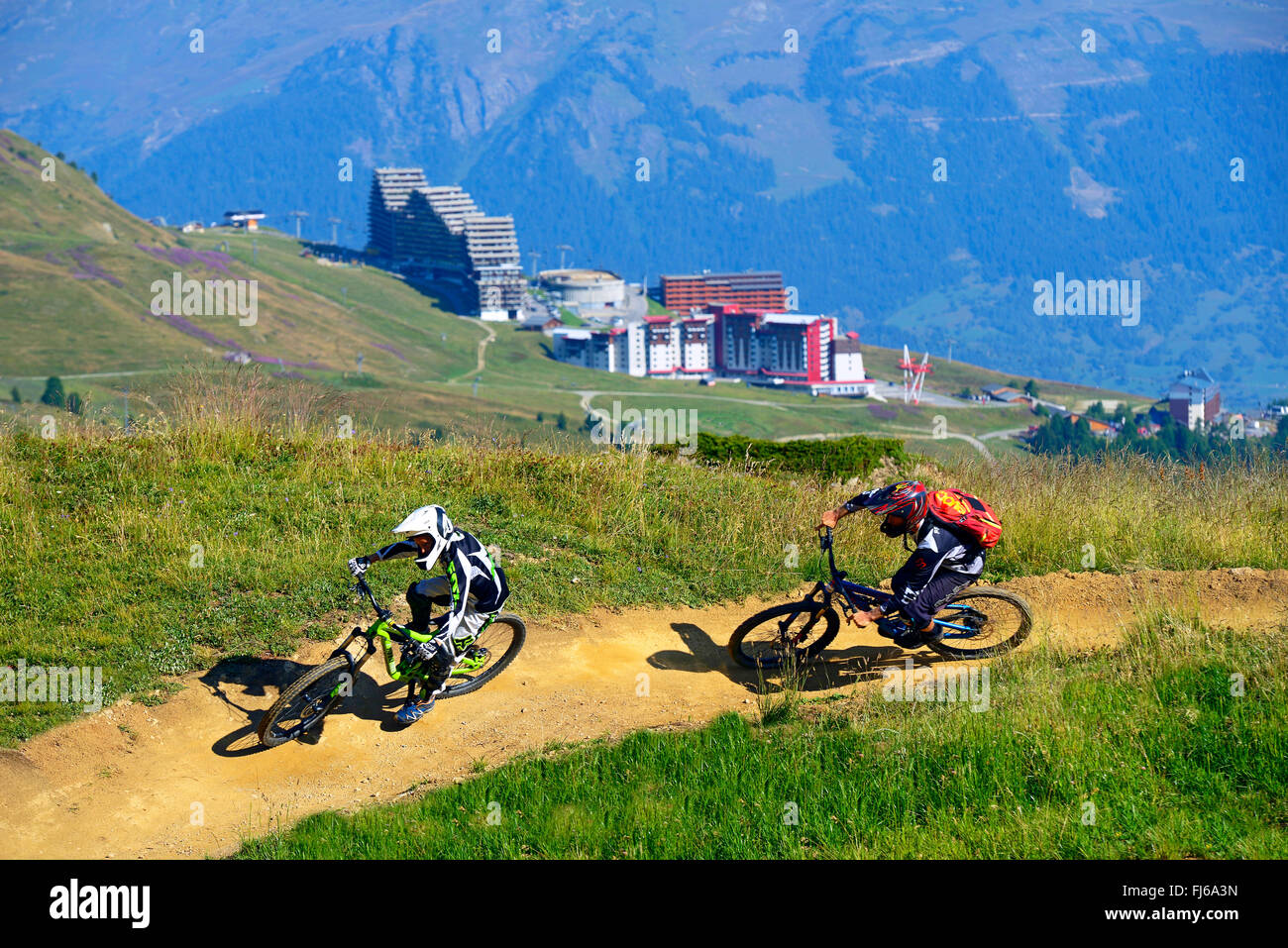 two mountain biker on a mountain trail, downhill, hotels of La Plagne in background, France, Savoie, La Plagne Stock Photo