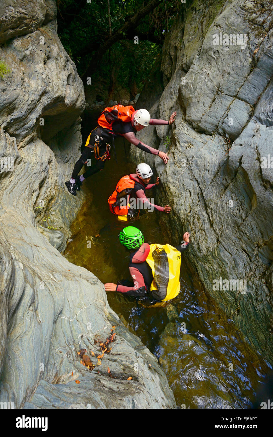 three persons climbing through a canyon, France, Corsica, Bastia Stock Photo