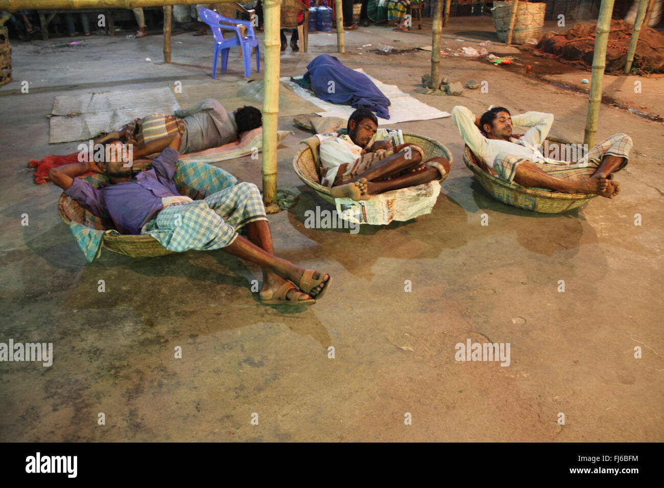 Dhaka, Bangladesh. 29 February, 2016. Daily laborers sleep on their basket which they use carrying vegetables at Karwan Bazar in Dhaka, Bangladesh on 29 February, 2016. They earn two dollar each a Day. Hundreds of migrant people live in busy city whose are arrived in Dhaka from different district in Bangladesh. Many of them lose their home by river erosion. Credit:  Rehman Asad/Alamy Live News Stock Photo