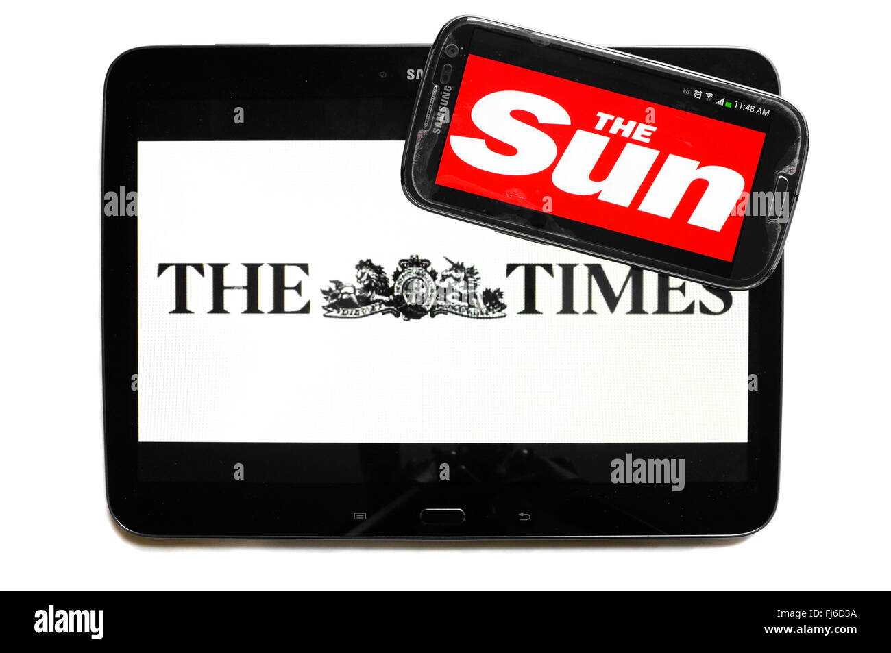 The logos of The Times and The Sun newspapers displayed on the screens of a tablet and a smartphone. Stock Photo