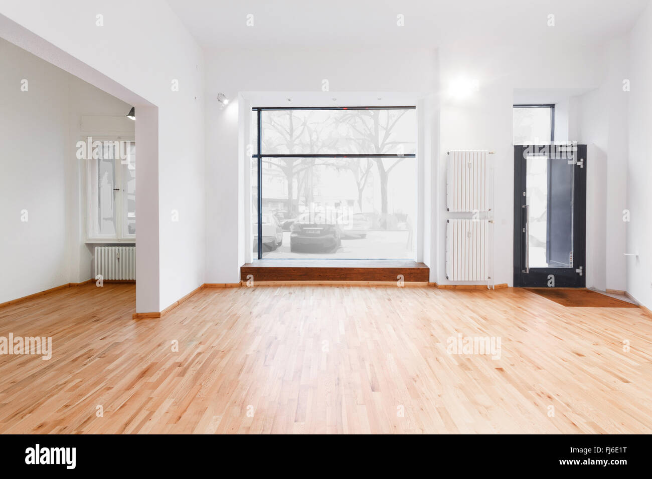 renovated room with shopping window - empty store / shop with wooden floor and white walls Stock Photo