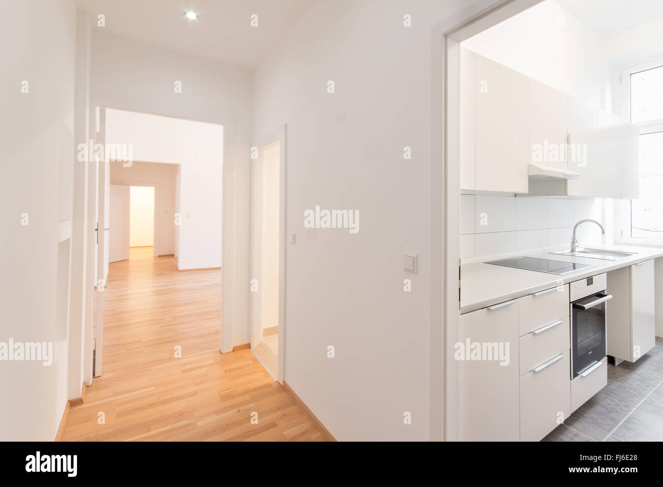 fresh renovated flat - home / apartment - renovated flat , corridor and kitchen, white walls and wooden floor Stock Photo