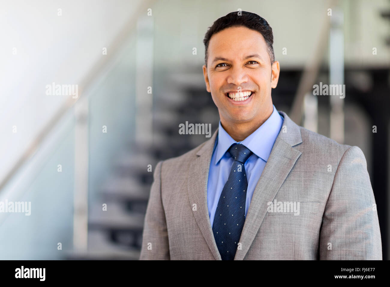 cheerful businessman standing by stairway Stock Photo