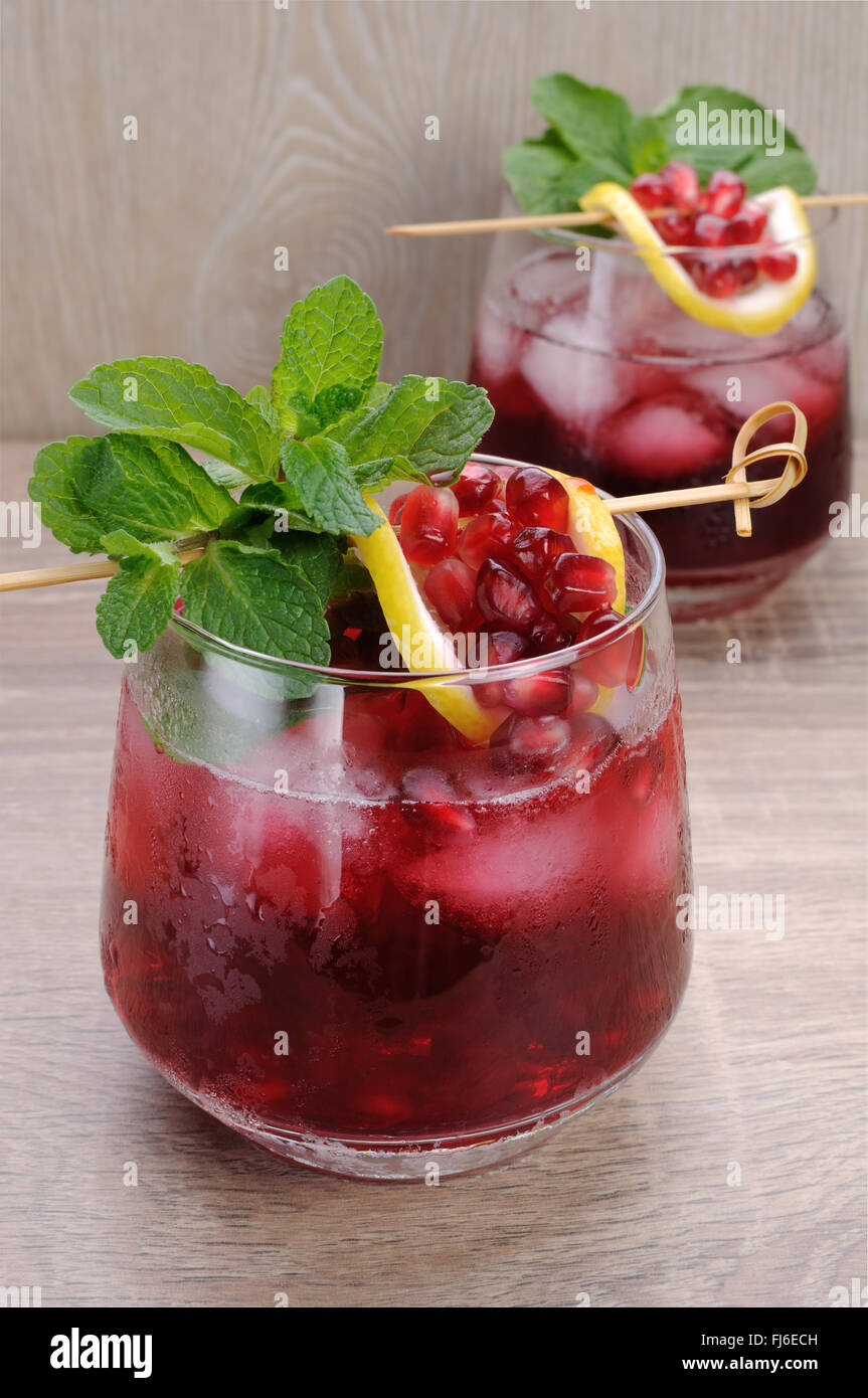 Pomegranate cocktail with slices of lime, mint and ice Stock Photo