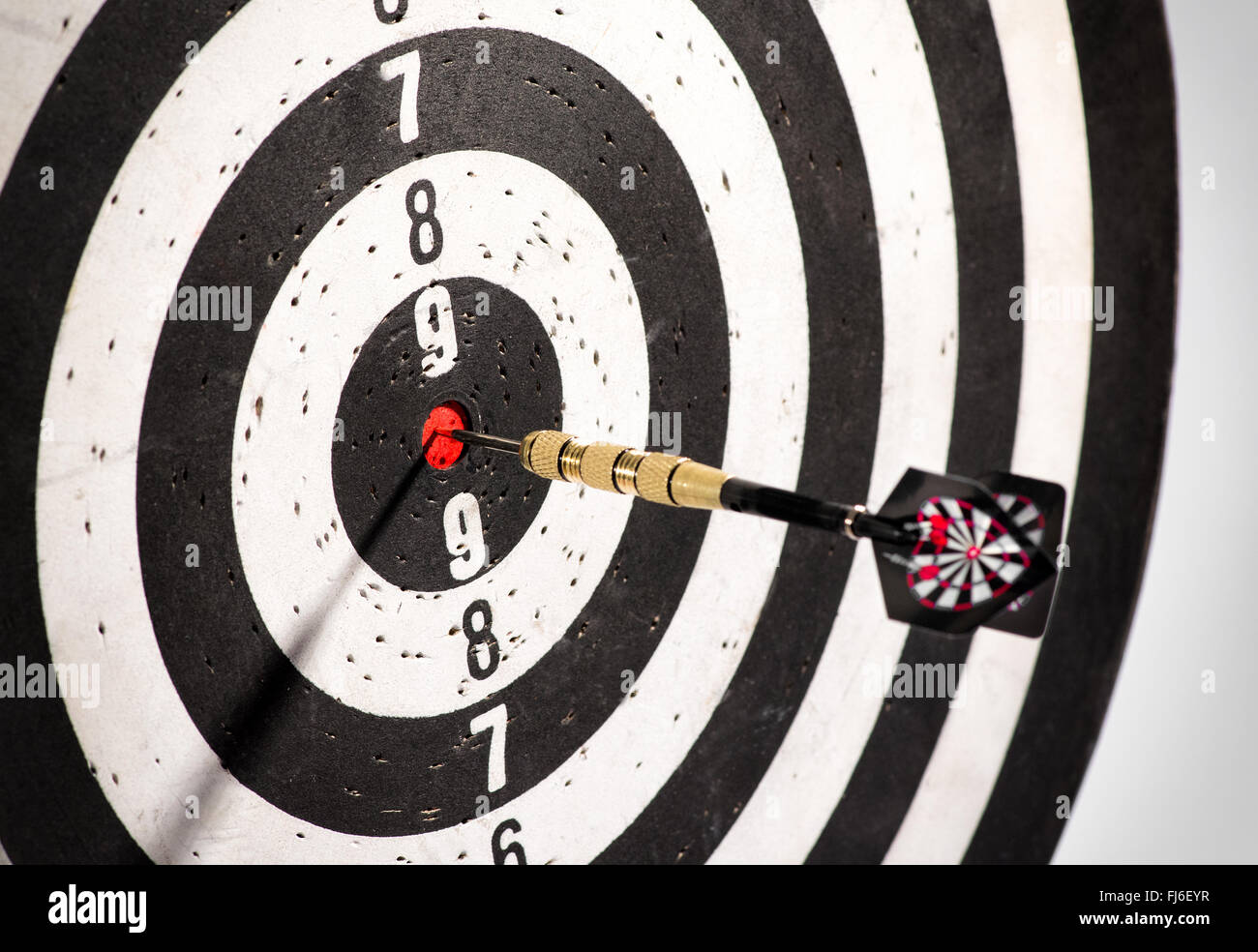 Dart in the bulls eye center of a dart board or black and white target Stock Photo