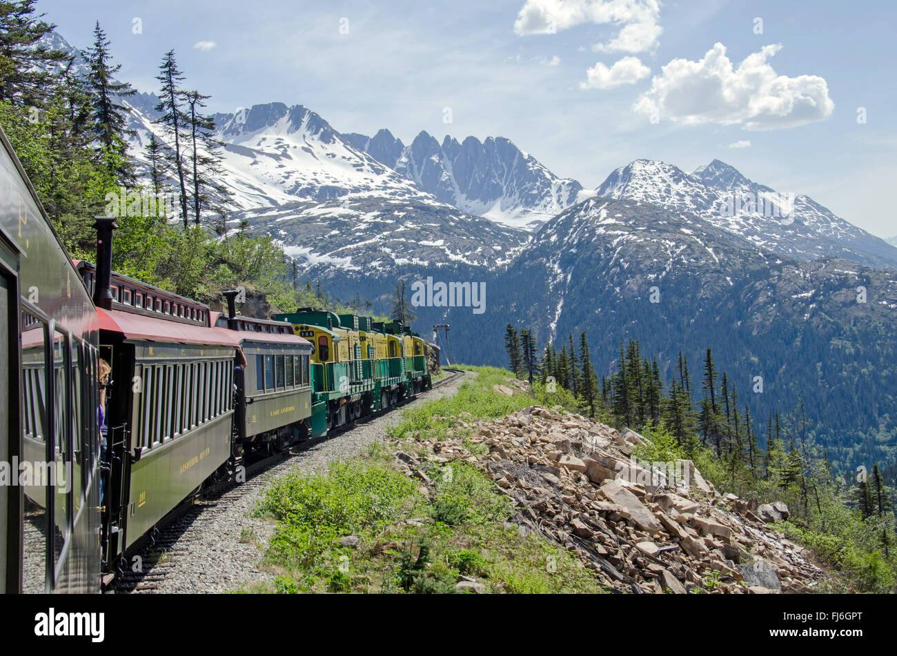 White Pass & Yukon Route Railroad travels along the cliffs heading towards Skagway, Alaska Stock Photo