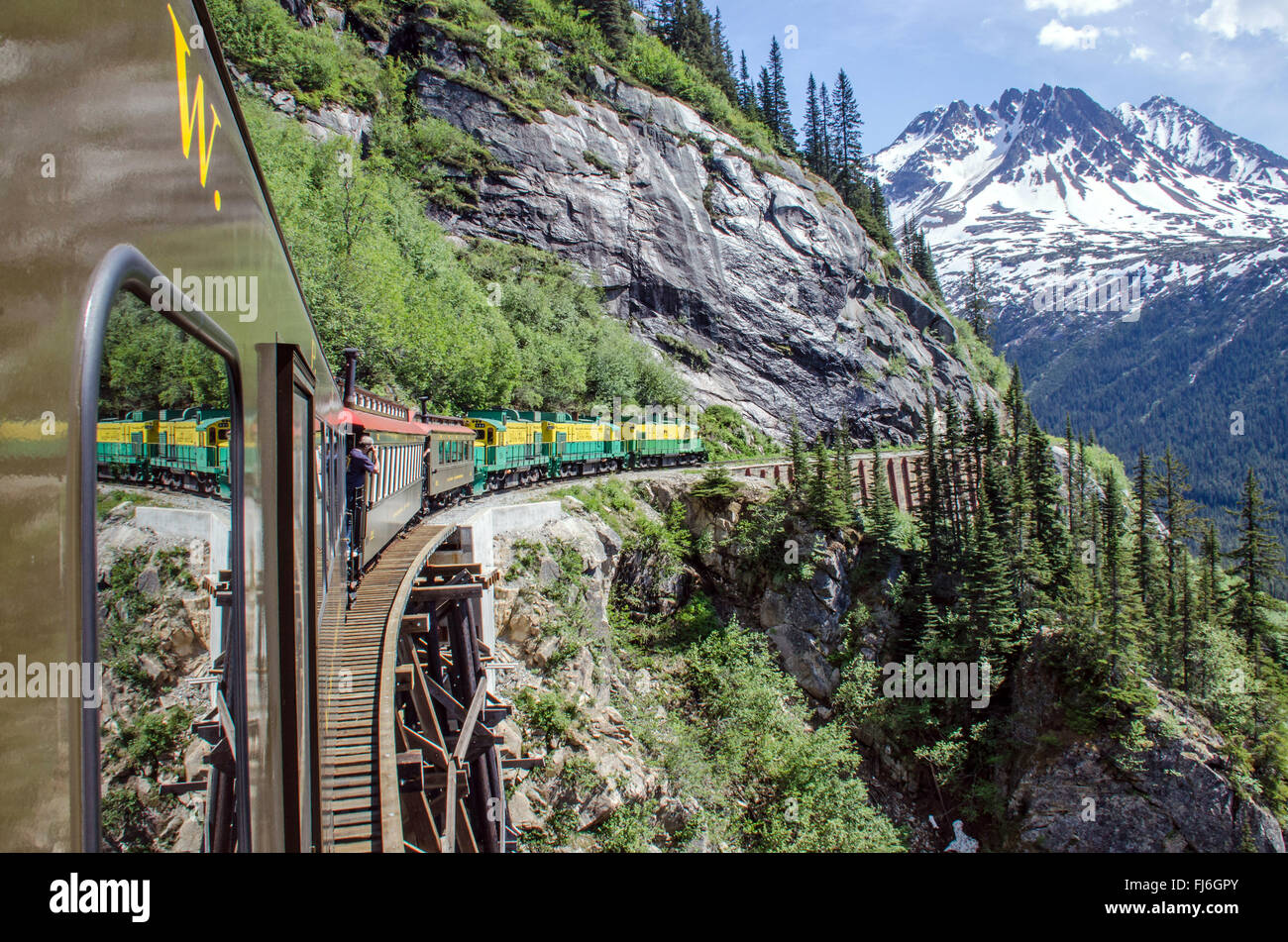White Pass & Yukon Route Railroad travels along the cliffs heading towards Skagway, Alaska Stock Photo