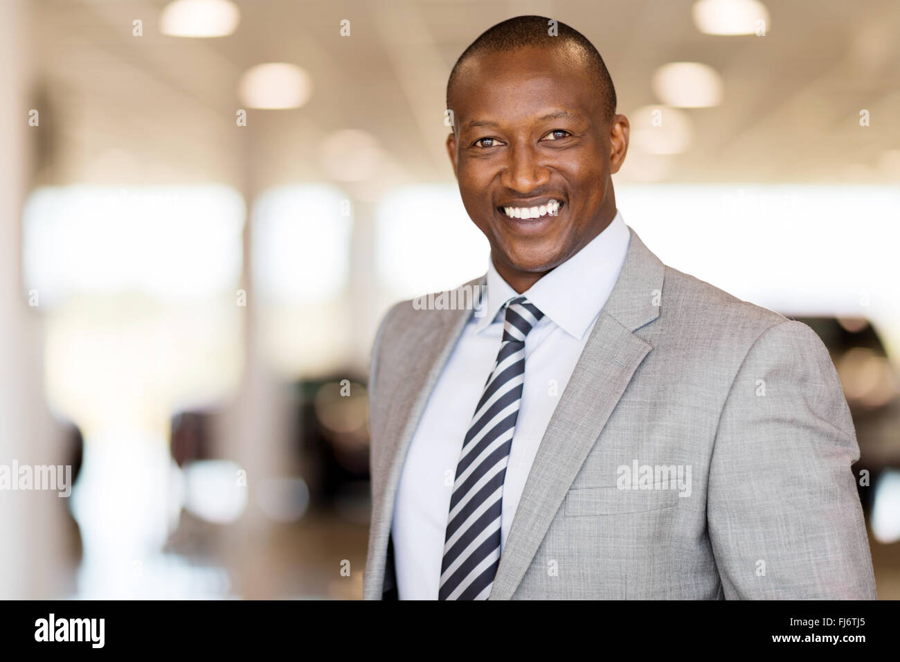 handsome African man working at car dealership Stock Photo