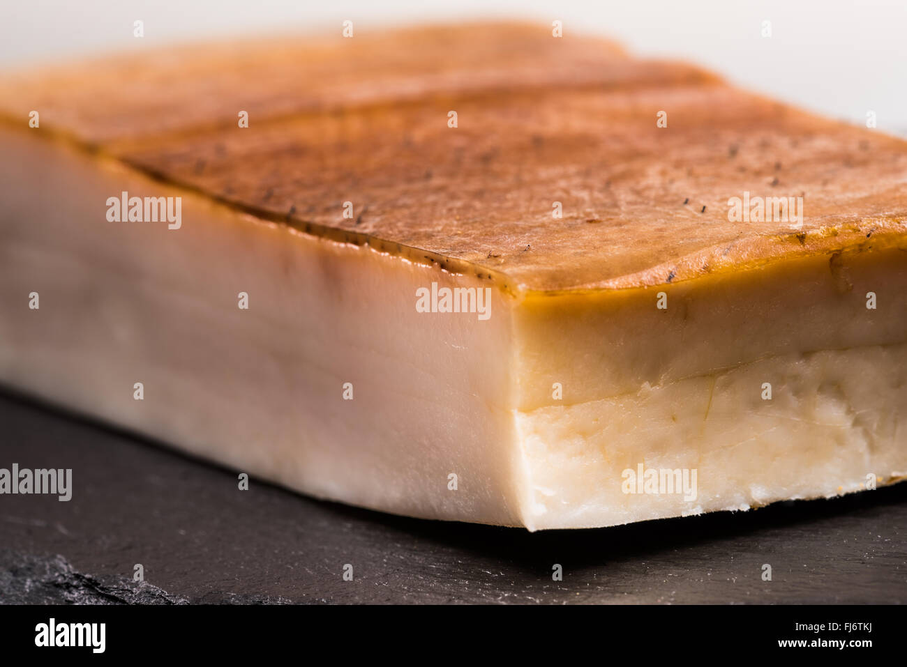 Fat bacon on a black background, bill, pork belly, rind, smoked, skin, calories, diet, flavor, plate, postion, white, tasty, fla Stock Photo