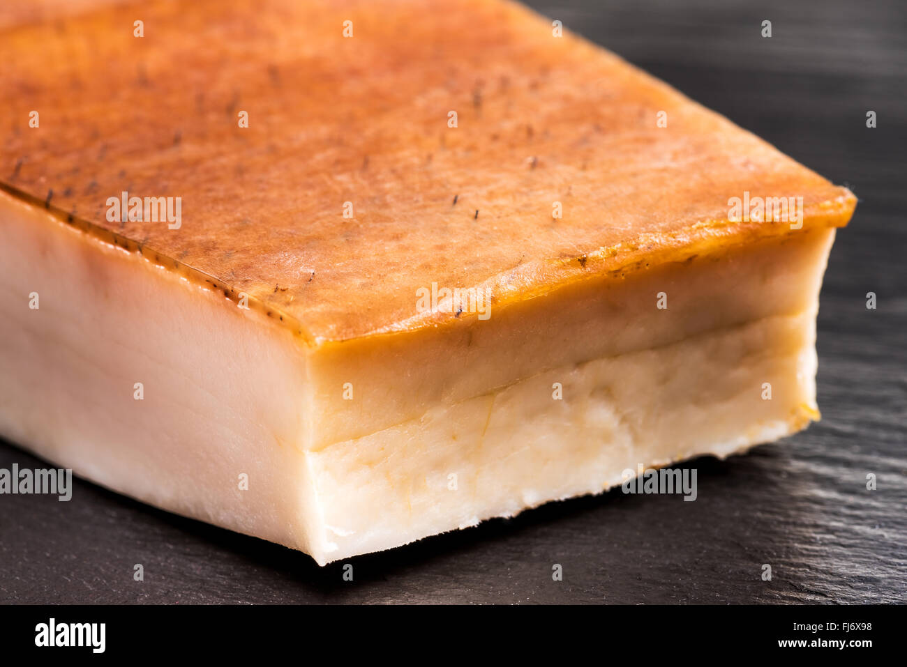 Fat bacon on a black background, bill, pork belly, rind, smoked, skin, calories, diet, flavor, plate, postion, white, tasty, fla Stock Photo