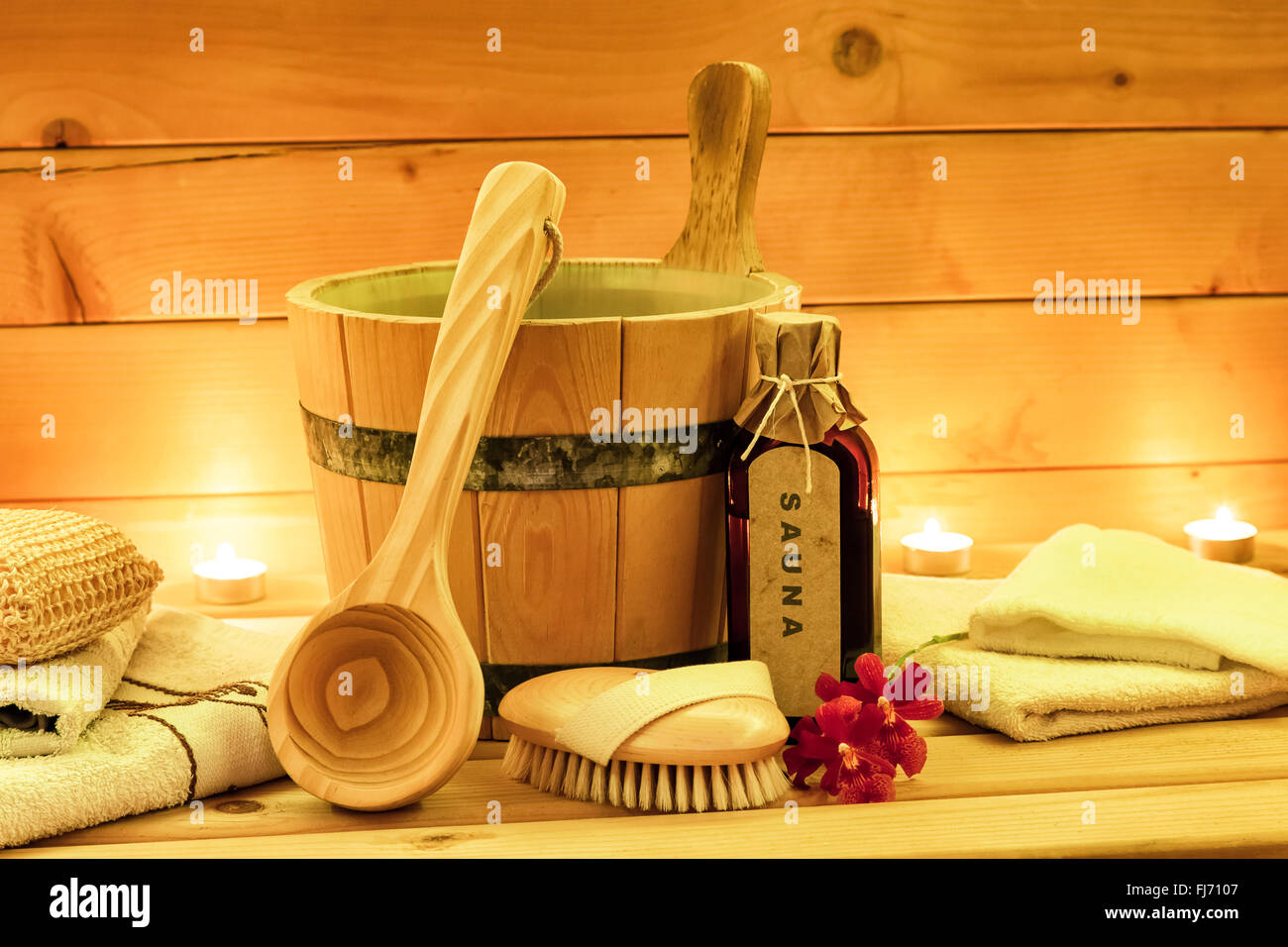 Sauna accessories with sauna oil, wooden bucket, ladle, towels Stock Photo