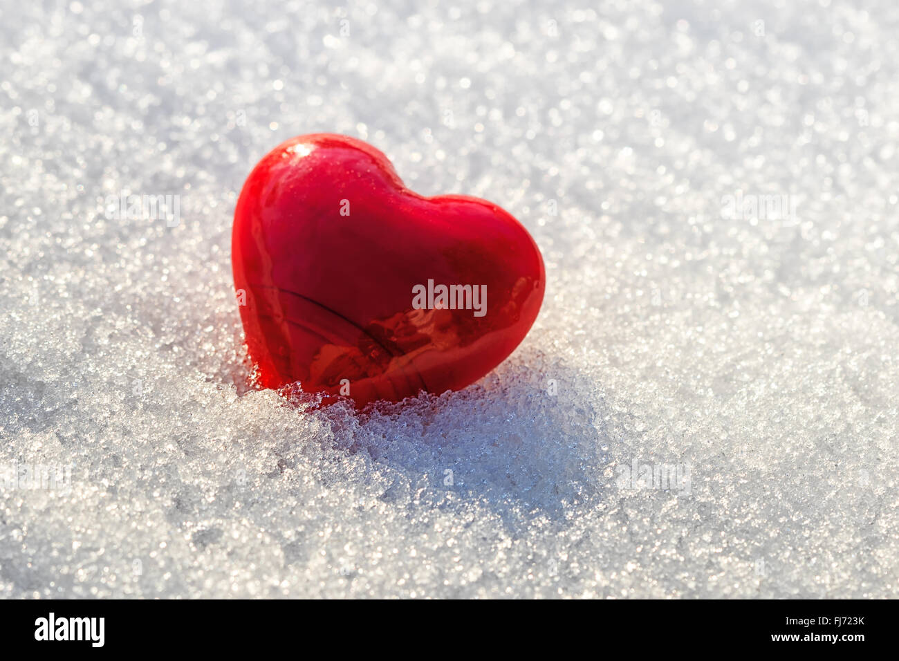 red heart on ice wet snow, selective focus, outdoors image Stock Photo