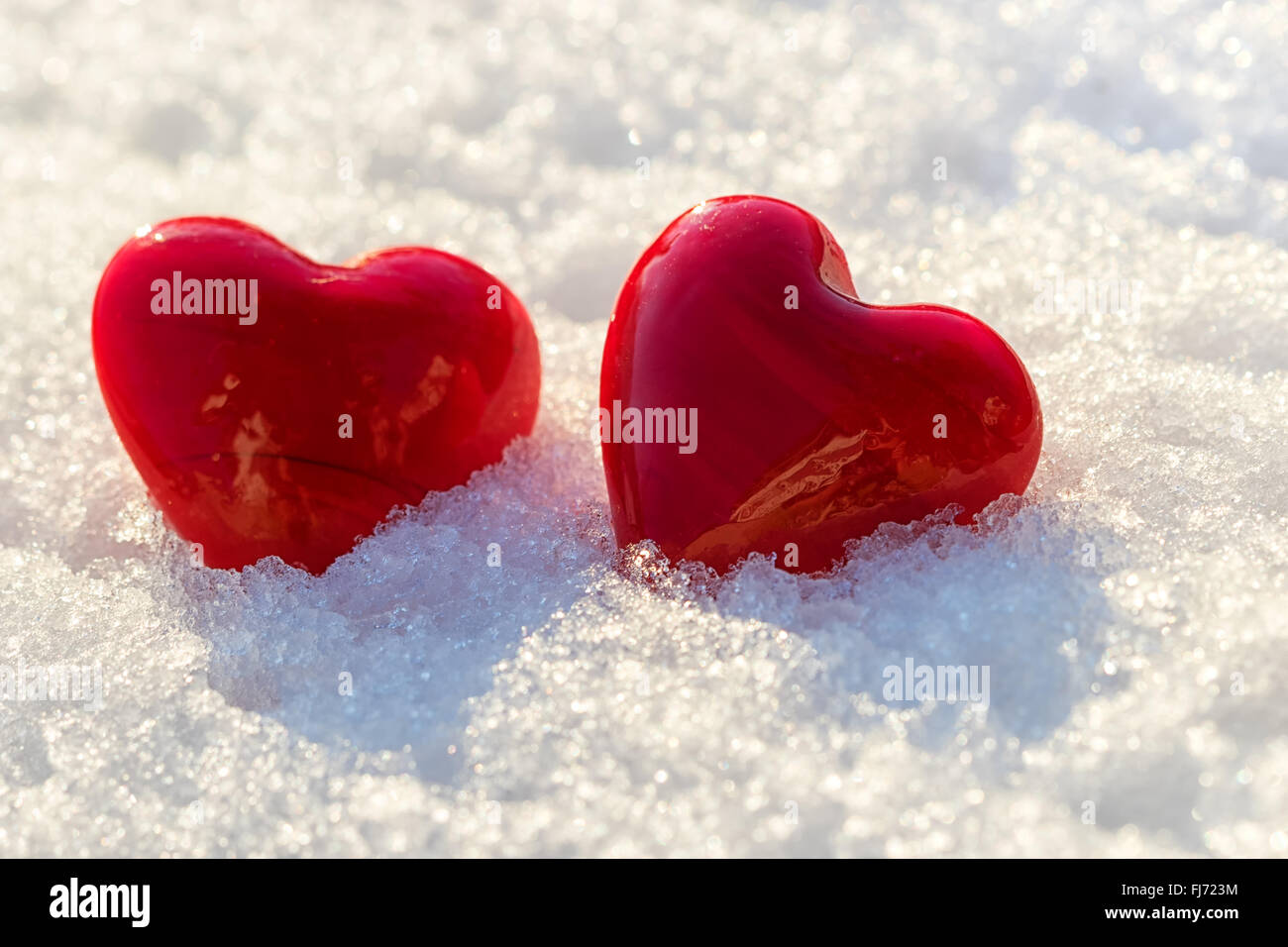 two red hearts on ice wet snow, selective focus, outdoors image Stock Photo