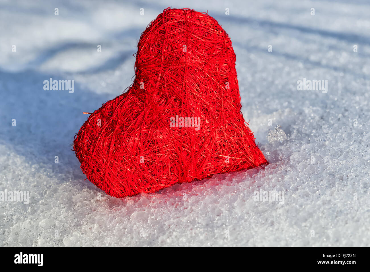 Valentines red heart on ice wet snow, selective focus, outdoors image Stock Photo