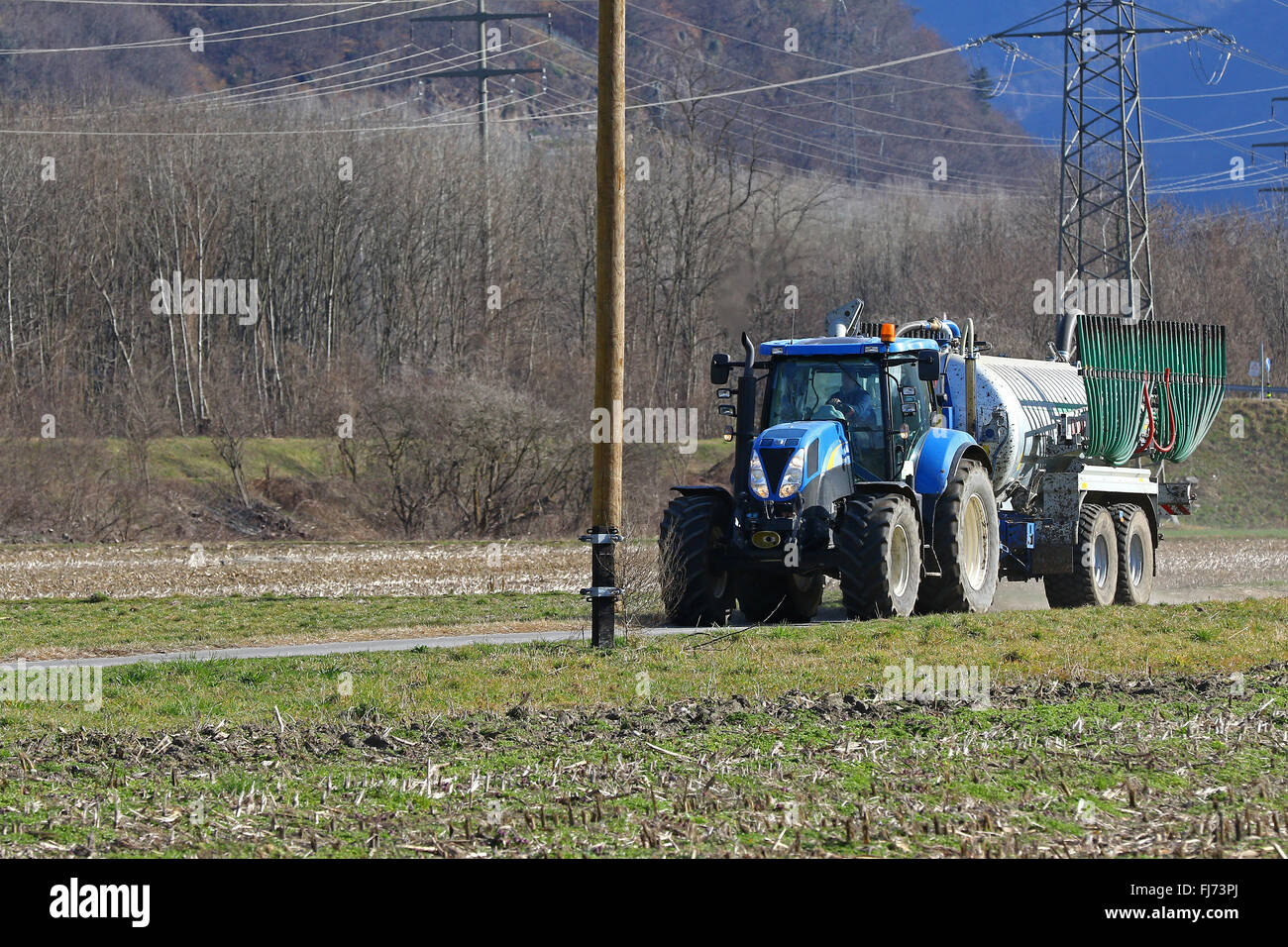 Agricultural tractor pulling a trailer on a farm road Stock Photo Alamy
