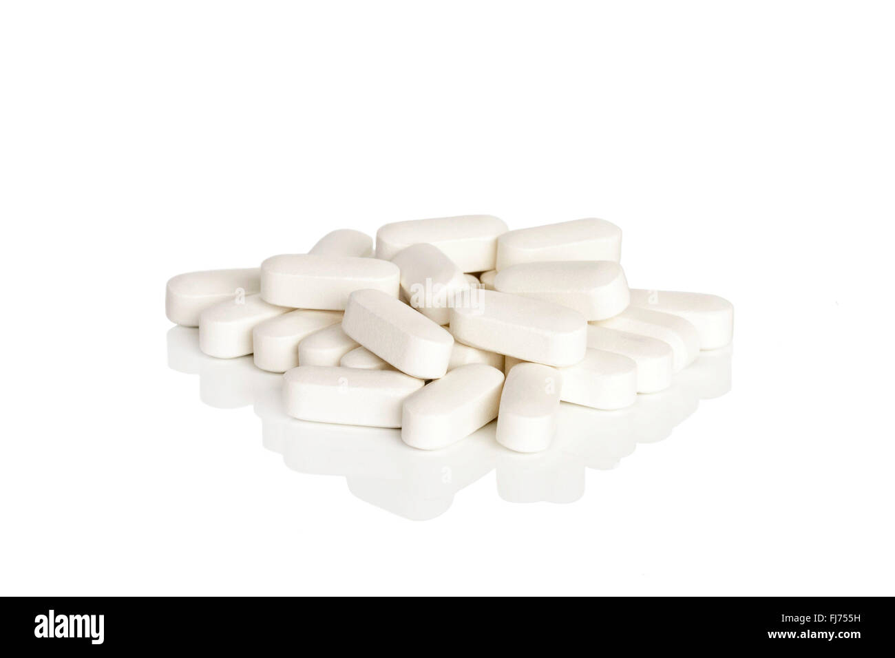 A pile of calcium vitamin supplement tablets isolated on a white background. Stock Photo