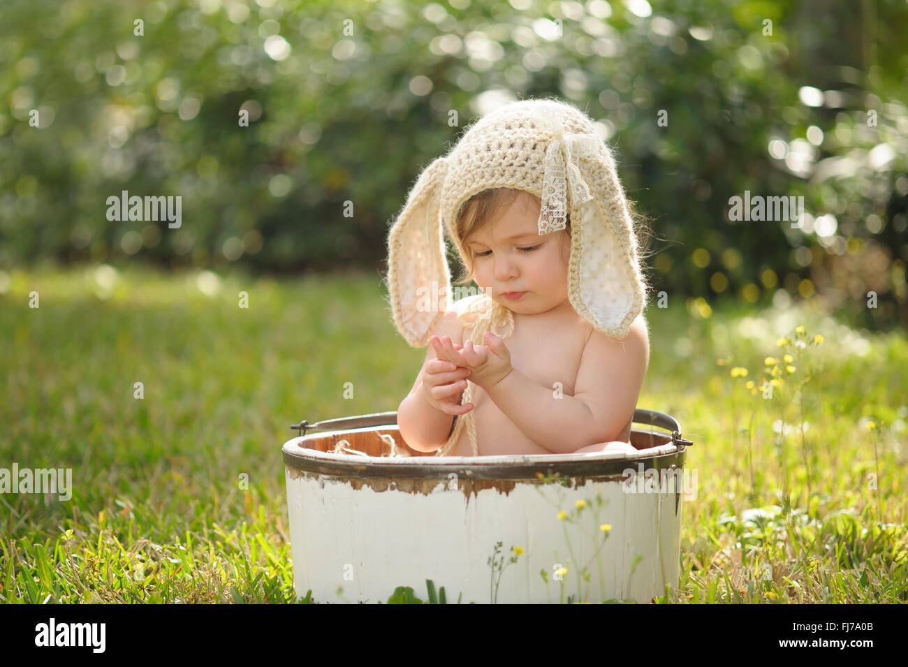 A baby girl wearing a crocheted, bunny bonnet. Stock Photo