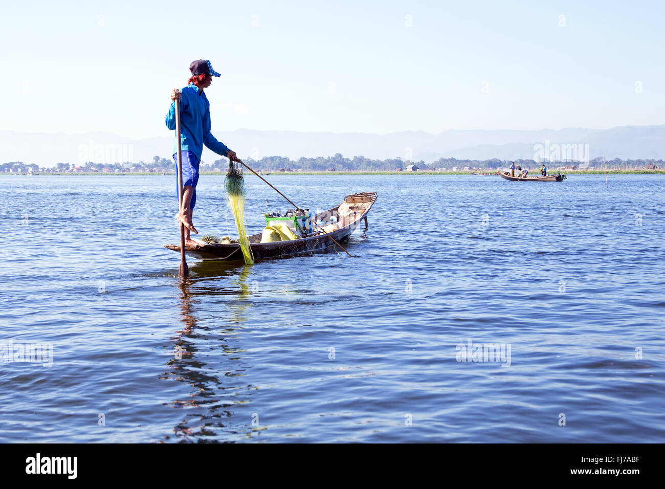 INLE LAKE, MYANMAR - November 15, 2015: Intha people possess the unique leg-rowing style on Inle Lake, Myanmar Stock Photo