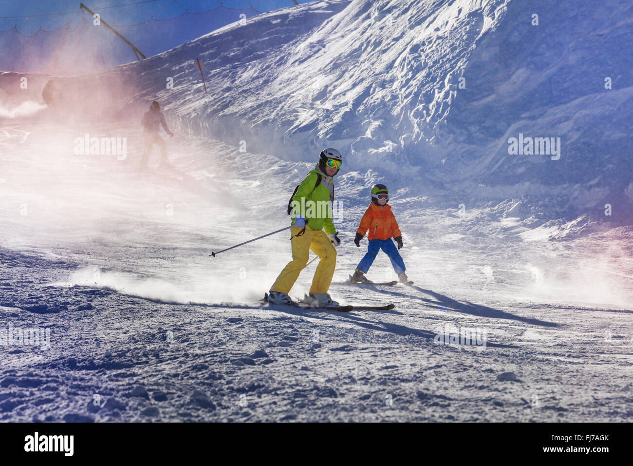 Mother and son ski down the mountain Stock Photo