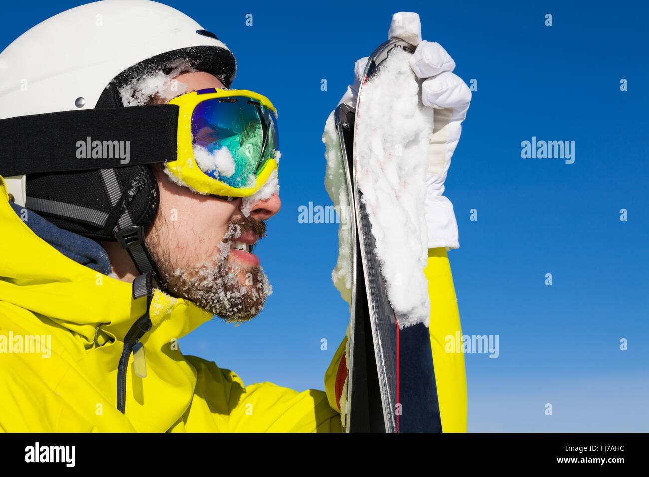 Close portrait of man holding ski Stock Photo